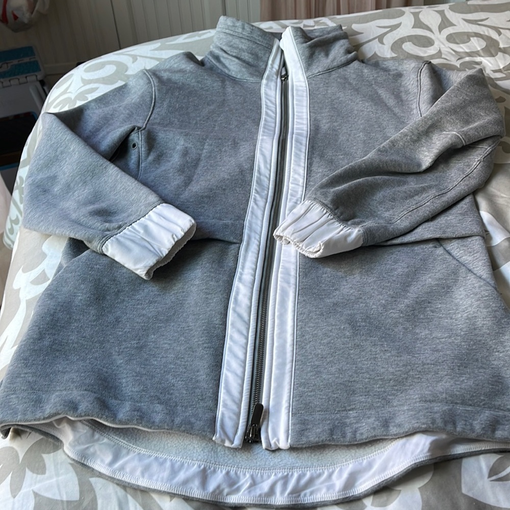 Amazing Lululemon grey long jacket with white trim pockets and adjustable waist.